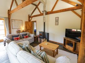 A living room with a wood stove and sofa at Robbie's Barn Fulready near Stratford-upon-Avon