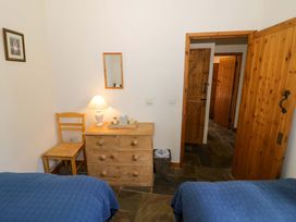 A bedroom with two beds, a dresser, and a chair at Robbie's Barn Fulready near Stratford-upon-Avon