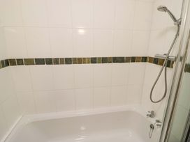 A bathroom with a bathtub and shower at Robbie's Barn Fulready near Stratford-upon-Avon