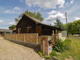 A holiday cottage with wooden fence and sign at Robbie's Barn in Fulready near Stratford-upon-Avon