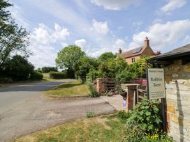 A cottage with a sign in front at Robbie's Barn Fulready near Stratford-upon-Avon