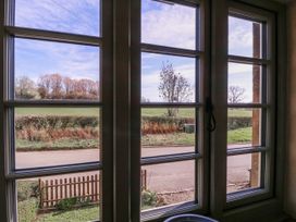 A view from a window showing trees, a field, and a road at Elm View Chipping Campden