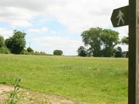 A field with trees and a signpost at Elm View Chipping Campden