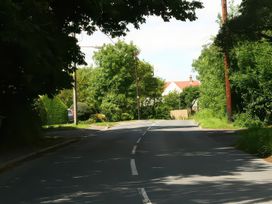 A street lined with trees and houses at Elm View in Chipping Campden