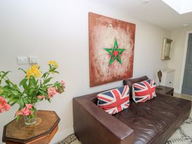 A living room with a couch and flower vase at Fairview Cottage in Milton-Under-Wychwood