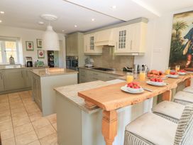 A kitchen with countertop and stools at Fairview Cottage in Milton-Under-Wychwood