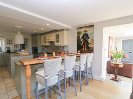 A kitchen with bar stools and a countertop at Fairview Cottage in Milton-Under-Wychwood
