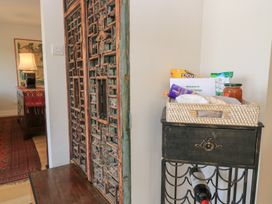 A hallway with a decorative door and a basket of snacks at Fairview Cottage in Milton-Under-Wychwood
