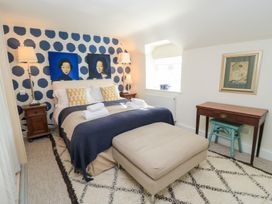A bedroom with a bed and artwork at Fairview Cottage in Milton-Under-Wychwood