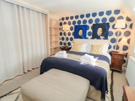 A bedroom with a bed and paintings at Fairview Cottage in Milton-Under-Wychwood