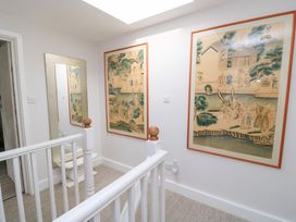 A hallway with wall art and a mirror at Fairview Cottage in Milton-Under-Wychwood