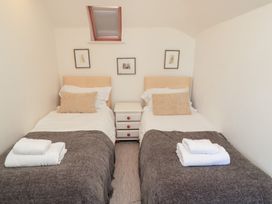 A bedroom with two beds and wall art at Fairview Cottage in Milton-Under-Wychwood