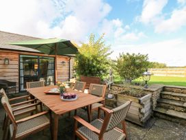 An outdoor dining area with a table and umbrella at Fairview Cottage in Milton-Under-Wychwood