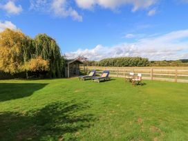 A garden with sun loungers and a wooden shed at Fairview Cottage Milton-Under-Wychwood