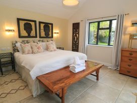 A bedroom with a bed and artwork at Fairview Cottage in Milton-Under-Wychwood