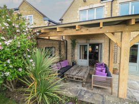 An outdoor seating area with a table and sofa at Fairview Cottage in Milton-Under-Wychwood