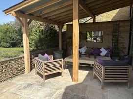 An outdoor patio with seating and a table at Fairview Cottage in Milton-Under-Wychwood