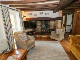 A living room with armchairs and a fireplace at Elmhurst Cottage in Lower Quinton