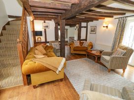 A living room with sofas and a staircase at Elmhurst Cottage in Lower Quinton