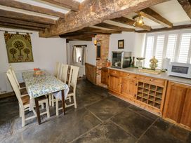 A kitchen with a dining table and cabinets at Elmhurst Cottage in Lower Quinton
