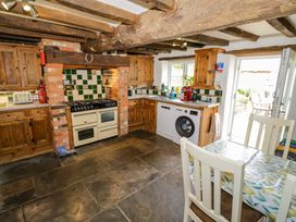 A kitchen with appliances and cabinets at Elmhurst Cottage in Lower Quinton