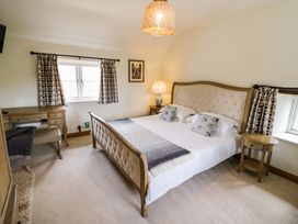A bedroom with a bed and desk at Elmhurst Cottage in Lower Quinton