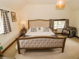 A bedroom with a bed and lamp at Elmhurst Cottage in Lower Quinton