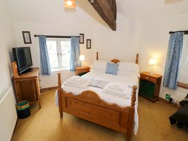 A bedroom with a bed and television at Elmhurst Cottage in Lower Quinton