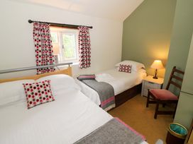 A bedroom with two beds and a window at Elmhurst Cottage in Lower Quinton