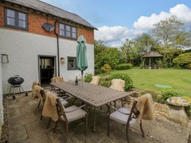 A patio area with a table and chairs at Elmhurst Cottage in Lower Quinton