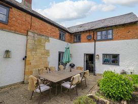 An outdoor dining area with a table and chairs at Elmhurst Cottage in Lower Quinton