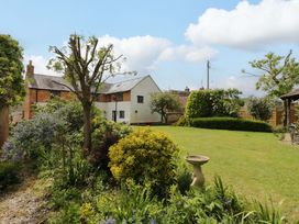 A house with a garden and trees at Elmhurst Cottage in Lower Quinton