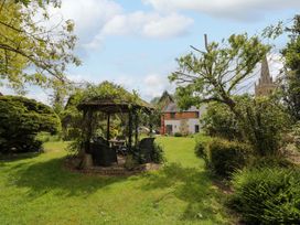 A garden with a gazebo and chairs at Elmhurst Cottage in Lower Quinton