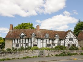 A house with a garden and fence at Elmhurst Cottage Lower Quinton