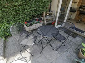 A table and chairs on a stone patio at The Old Reading Room in Bledington near Stow-on-the-Wold