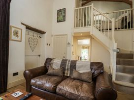 A living room with a sofa and staircase at The Old Reading Room in Bledington near Stow-on-the-Wold