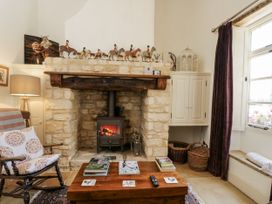 A living room with a fireplace and rocking chair at The Old Reading Room Bledington near Stow-on-the-Wold