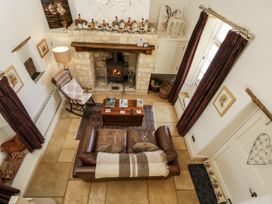 A living room with a fireplace and sofa at The Old Reading Room in Bledington near Stow-on-the-Wold