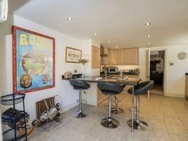 A kitchen with bar stools and appliances at The Old Reading Room Bledington near Stow-on-the-Wold