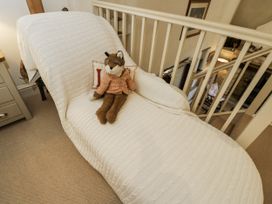 A chaise longue with a plush toy on it at The Old Reading Room Bledington near Stow-on-the-Wold