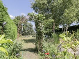 A garden with an archway and plants at The Old Reading Room Bledington near Stow-on-the-Wold