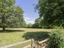 A field with trees and a wooden fence at The Old Reading Room Bledington near Stow-on-the-Wold