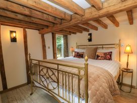 A bedroom with a bed and side tables at The Linhay in Little Coxwell near Faringdon