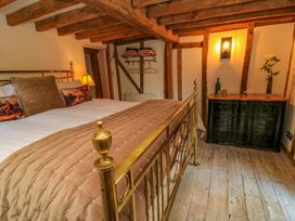 A bedroom with a bed and dresser at The Linhay in Little Coxwell near Faringdon