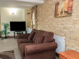 A living room with a sofa and television at Tithe Barn, Lyneham