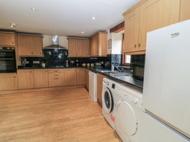 A kitchen with cabinets, a sink, and appliances at Tithe Barn, Lyneham