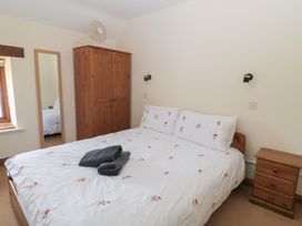 A bedroom with a bed and wardrobe at Tithe Barn, Lyneham