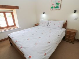 A bedroom with a bed and a window at Tithe Barn, Lyneham