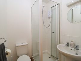 A bathroom featuring a shower, toilet, and wash basin at Tithe Barn, Lyneham