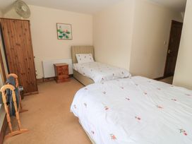 A bedroom with two beds and a dresser at Tithe Barn, Lyneham